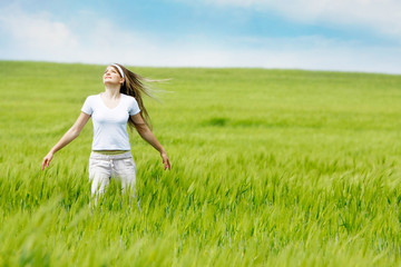 Fototapeta na wymiar young happy woman in green field