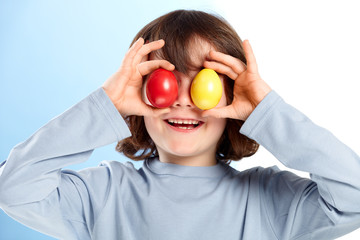 Little boy playing with colored easter eggs