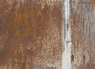 orange brown rusty metal surface with a white line running verti