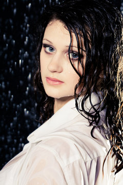 beautiful girl in the rain against a dark background