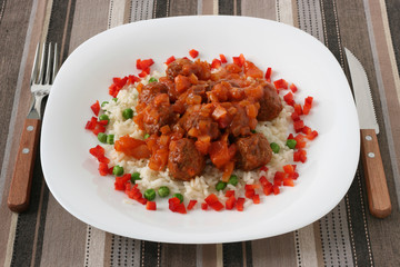 meatballs with boiled rice with peas and pepper