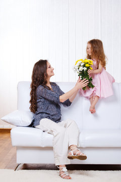 Girl presenting mother flowers