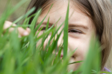 closeup portrait of little girl on green grass