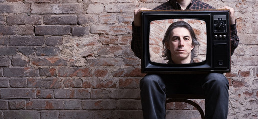 A man holding a retro television