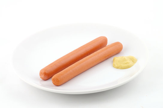 deux saucisses et de la moutarde dans un plat