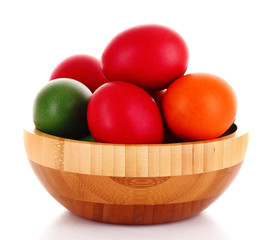 Easter eggs in wooden bowl isolated on white