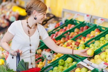 junge frau kauft gesundes obst
