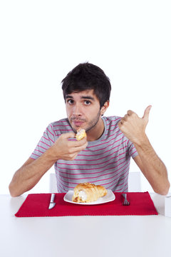 Young man eating a cake