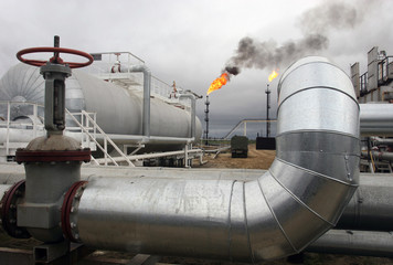 Set of pipes of oil factory against a flame