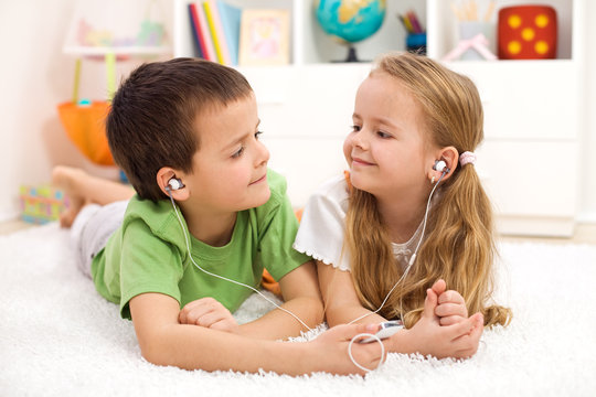 Kids Sharing Earphones Listening To Music