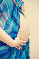 Belly of a pregnant woman with her hands on it