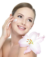 Happy teen with flower applying cream