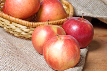 Apples on a sacking on a wooden table