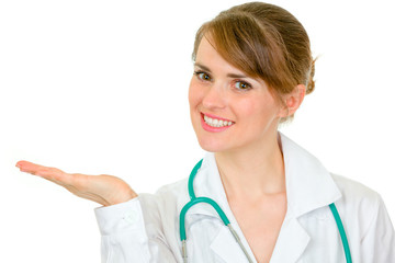Smiling doctor woman presenting something on empty hand
