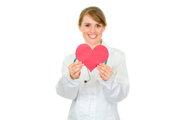 Smiling medical female doctor holding paper heart in hands