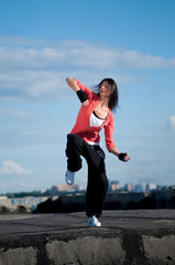 Fototapeta na wymiar woman dancing hip hop over blue sky