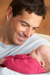 Obraz premium Portrait Of Father With Newborn Baby At Home