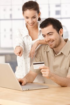 Happy couple shopping online having fun smiling