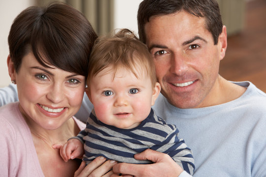 Portrait Of Proud Parents With Baby Son At Home