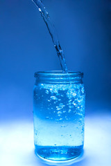 water flows into a glass jar forming bubbles