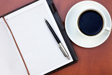 Coffee cup, notebook and pen