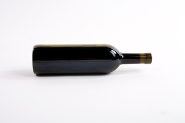 close-up of red wine bottle over white