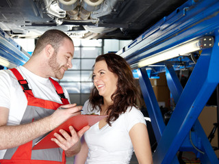 Motorcar mechanic explaining repair and maintenance costs