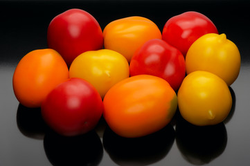 Multicolored tomatoes on a black backgrouns