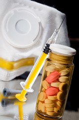Medicine bottle and sirynge and pills and mask