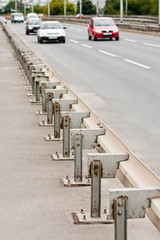 Highway guardrails with cars approaching from background