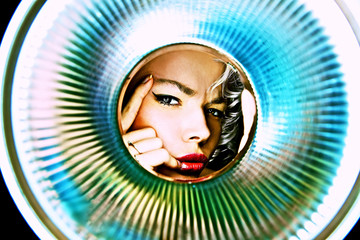 portrait of young girl observing through metal object.