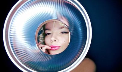 portrait of young girl observing through metal object.