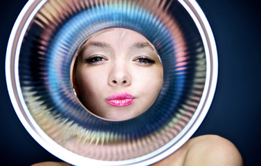 portrait of young girl observing through metal object.