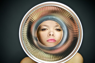 portrait of young girl observing through metal object.