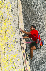 Rock climber clinging to a cliff.