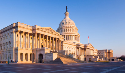 Fototapeta na wymiar Wschodzące słońce oświetla przód budynku Kapitolu w Waszyngtonie