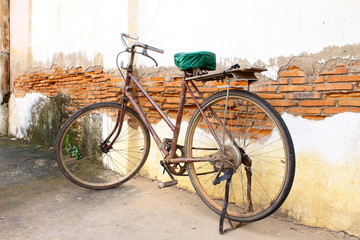 Fototapeta na wymiar Old bicycle against old wall