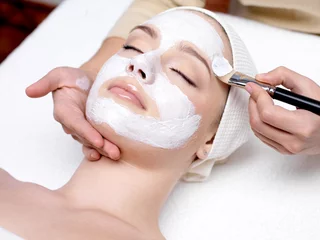 Wall murals Beauty salon Woman receiving facial mask at beauty salon