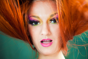 Fototapeta premium beautiful girl with multicolored make-up and red long hair