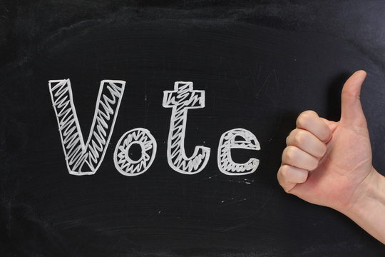 Thumbs up sign for the word Vote on a Blackboard