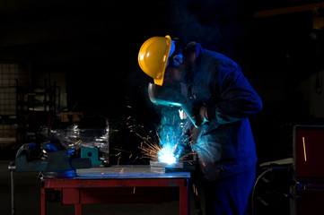 Worker making sparks while welding steel.
