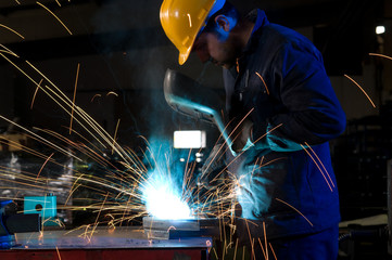 Worker making sparks while welding steel.