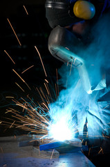 Worker making sparks while welding steel.