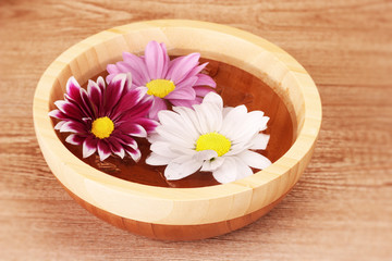 Pink and white flowers floating in bowl