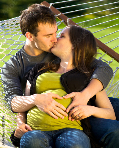 Young Expectant Husband And Wife Kissing Stock Photo Royalty Young Expectant Husband And Wife Kissing