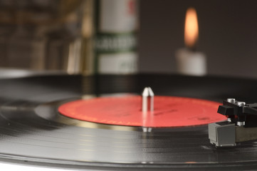 Old record player with a lit candle  in the background.