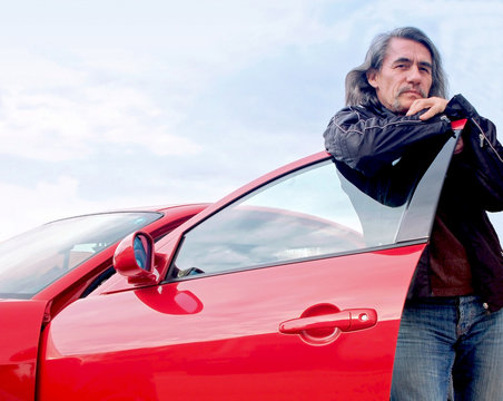 Mann mit seinem Sportwagen