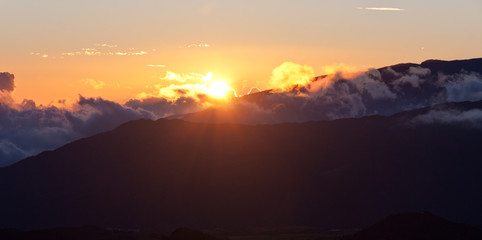 coucher de soleil derrière les montagnes