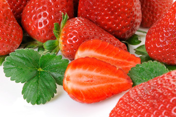 a pile of ripe strawberries with leaves