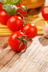 pasta, olive oil and tomatoes on the wood background